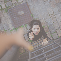 A woman at the end of a latter reaching out for help